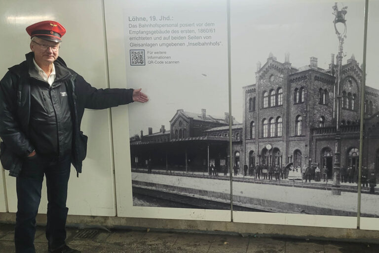 Aussichtsbeamter Martin Lorenz steht im Personentunnel vor einem Foto des alten Bahnhofs Löhne