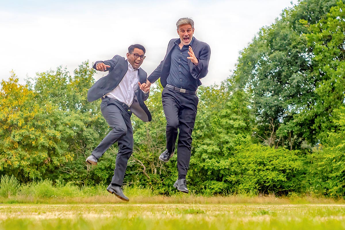 Boogielicious Duo springt in einer Landschaft in die Luft